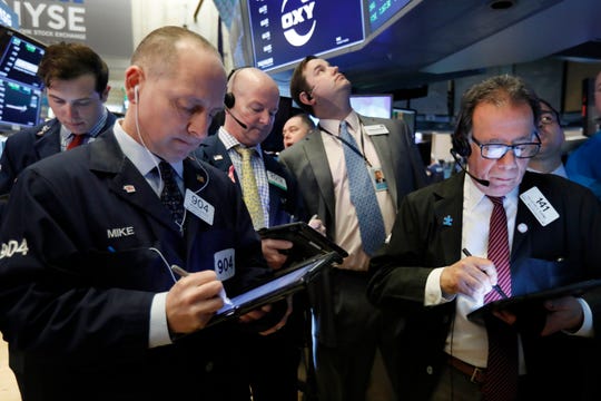 Traders gather on the floor of the New York Stock Exchange on March 13, 2019.