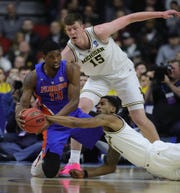 Michigan's Jon Teske (15) and Charles Matthews defend Florida's Kevarrius Hayes in the first half of their second round NCAA tournament game Saturday, March 23, 2019 at Wells Fargo Arena in Des Moines, Iowa.