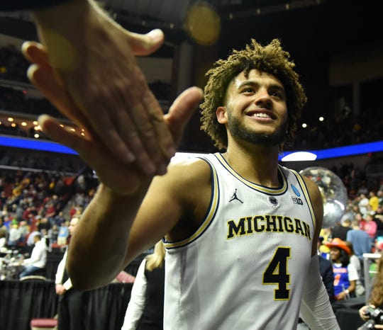 Striker Isaiah Livers (4) celebrates with his fans after Michigan's loss by Florida 64-49 on Saturday to reach the Sweet 16 for the third year in a row.