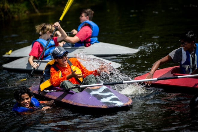 Boy Scouts Noel Zelaya, from left, Alex Gustin and Greesh Paruchuri splash each other after launching the kayaks they've been working on since September with their troop into the Imperial River at Riverside Park in Bonita Springs on Sunday, March 24, 2019.