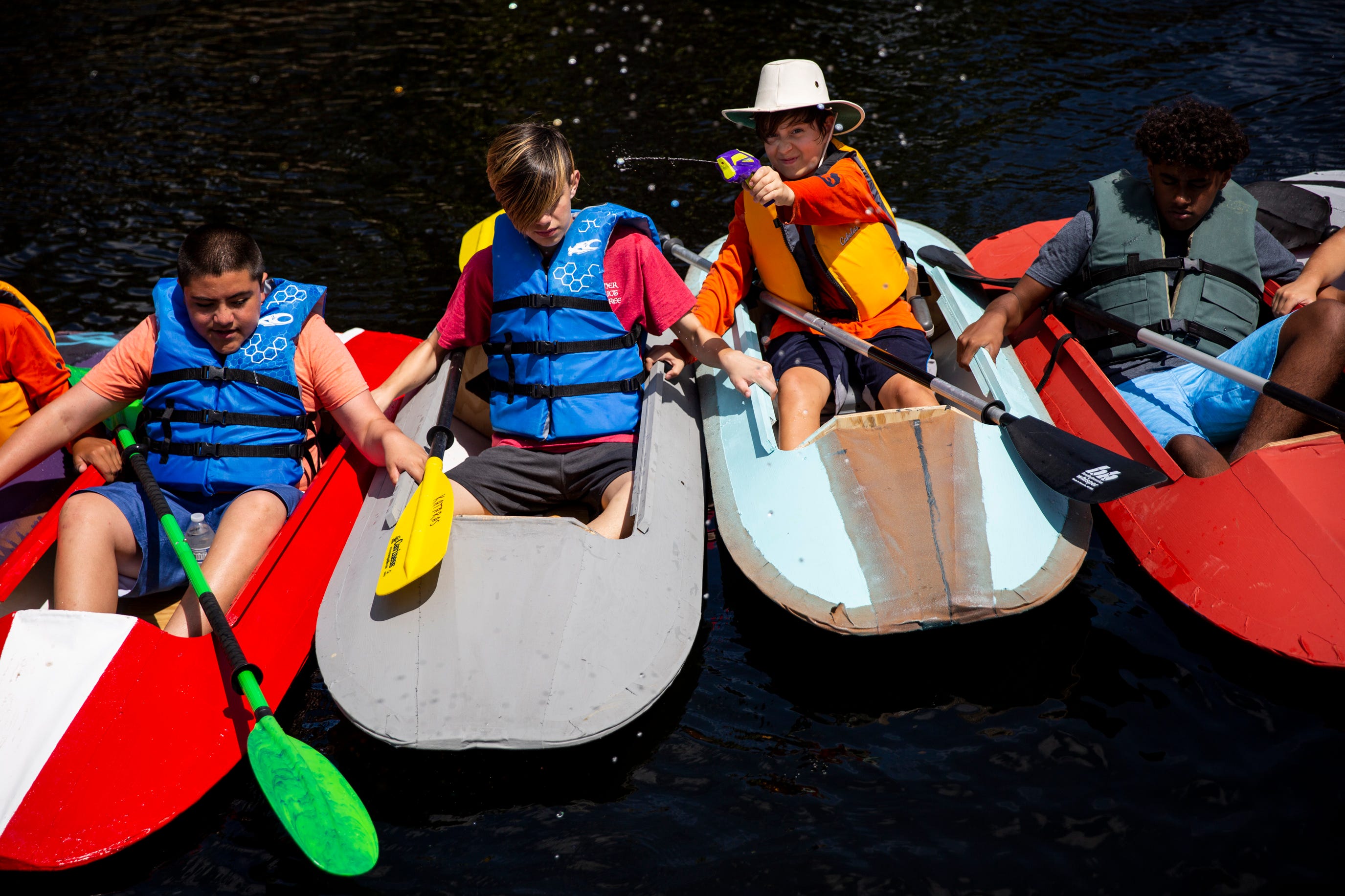 Julian Gustin shoots a water gun while he and other Boy Scouts from Troop 109 launch the kayaks they've been working on since September into the Imperial River at Riverside Park in Bonita Springs on Sunday, March 24, 2019.