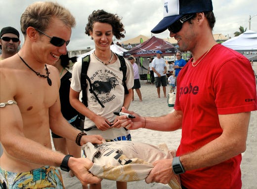 2009: Zach Cooney and his brother Harrison Cooney both of Cocoa Beach gets a autograph form CJ Hobgood of Satellite Beach as Crowds pack the beach behind Coconuts on the Beach for the Slater brothers Invitational surf event to watch local surf stars like Kelly Slater of Cocoa Beach and CJ Hobgood of Satellite Beach Sunday afternoon in Cocoa Beach.