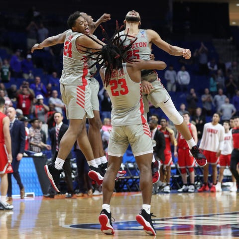 Houston Cougars players celebrate after defeating...