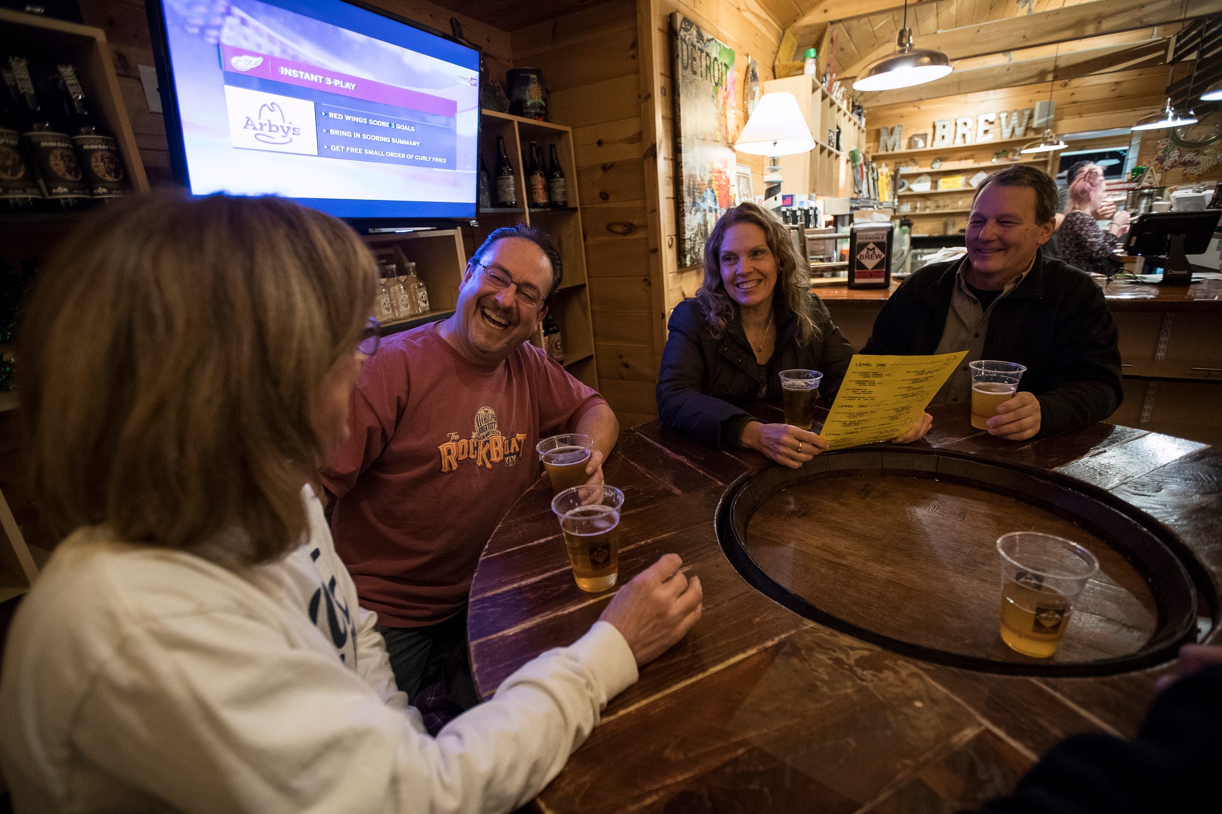From left, Debbie McGraw, Ed Jankowski, both of Downriver share a laughter with Lori and Dave Stoddart, both of Trenton, as they enjoy a drink at M-Brew in Ferndale, Thursday, March 7, 2019.
