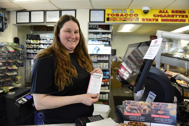 Brandy Nichols, manager of the Marathon station between Galion and Crestline, holds a freshly printed Powerball ticket Tuesday morning.