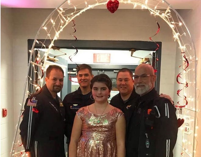 After her father died suddenly last year, Kylie Logan, 10, was left without a date for a father-daughter dance. Attending in his absence were members of flight paramdeic Patrick Logan's Atlantic Mobile Health flight team: from left, Art Samaras, Morgan Troisi, Paul Horsey, and Jim McGrath.
