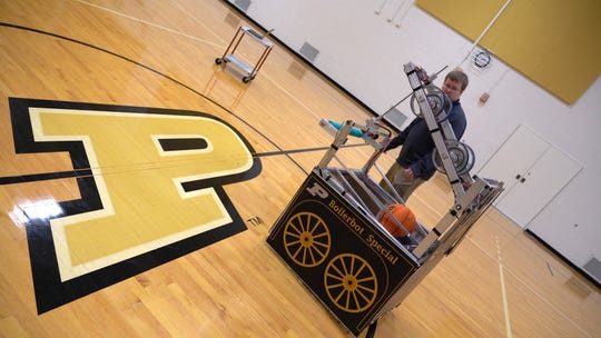 Michael Linnes, the robotic team's faculty advisor, helps test the BoilerBot Special at the co-rec.