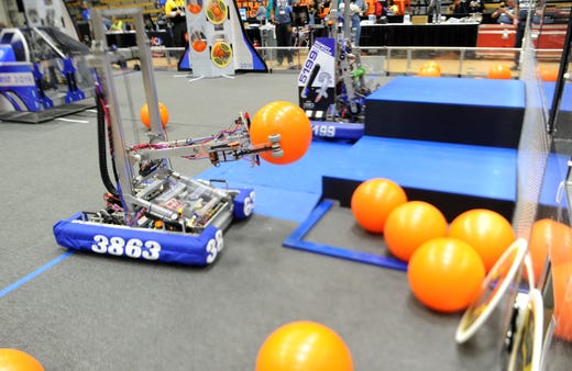 A robot from Newbury Park High School picks up the balls to get points Thursday during the the FIRST Robotics competition at the Ventura College gym.