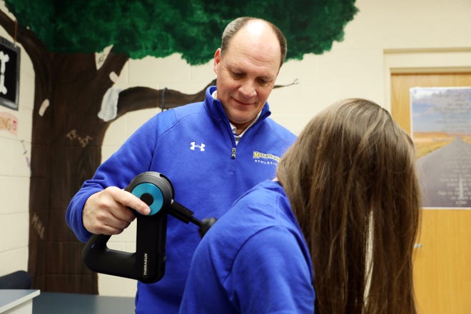 Maysville High School athletic trainer Joe Johnson helps sprinter Paige Webb get ready for track practice. Johnson was named the Athletic Trainer of the Year by the Ohio Athletic Trainers' Association.