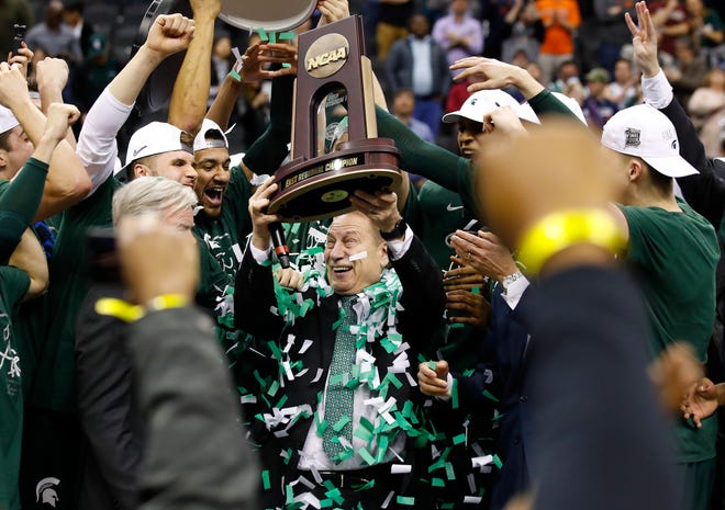 Michigan State head coach Tom Izzo holds up the NCAA men's East Regional Championship trophy after defeating Duke in a college basketball game in Washington, Sunday, March 31, 2019. Michigan State won 68-67. (AP Photo/Alex Brandon)