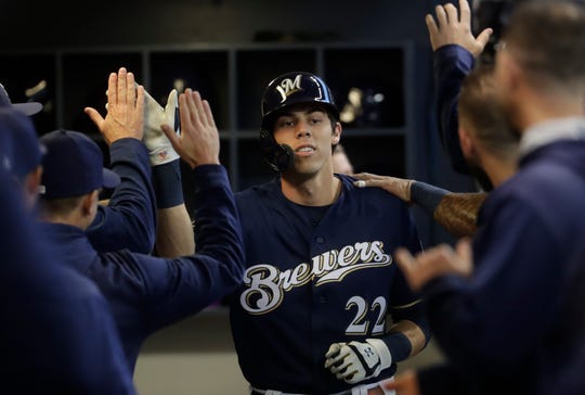 Christian Yelich is congratulated for his third homecoming in as many games Saturday night.