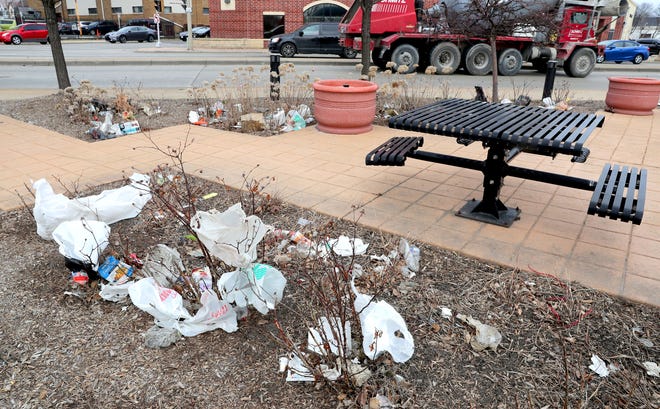 Plastic bags, trash and other litter cover bushes near the corner of West Fond du Lac Avenue and North 21st Street near West North Avenue in Milwaukee on Monday. As of Monday, anyone caught littering in the city will now face a $500 fine.