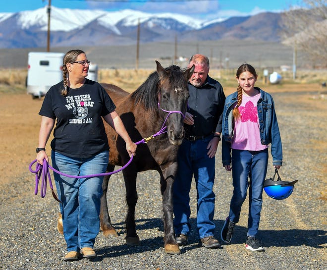 Bob and Nadine Hastings and granddaughter Jordan walk their horse, Madison.