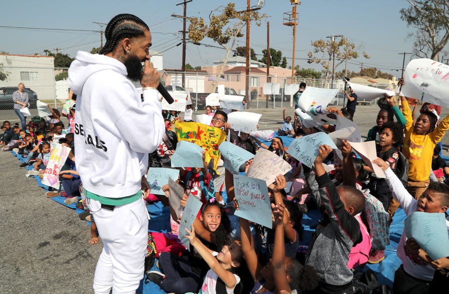 Nipsey Hussle speaks to kids at the Nipsey Hussle x PUMA Hoops Basketball Court Refurbishment Reveal Event on Oct. 22, 2018, in Los Angeles.