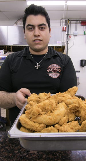 Dylan Kamano, manager of Ultimate Pizza & Chicken, holds a tray of deep fried chicken nuggets Wednesday, April 3, 2019, which will be featured at Saturday's Taste of Livingston.