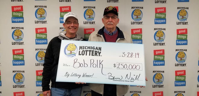 St. Clair resident Bob Polk, right, stands with his stepson, Bryan, after collecting Bob’s $250,000 prize in March 2019.