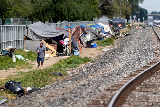 Dozens of homeless have set up shelters along the railroad tracks west of J Street between Prosperity and Cross avenues on Wednesday, April 3, 2019.