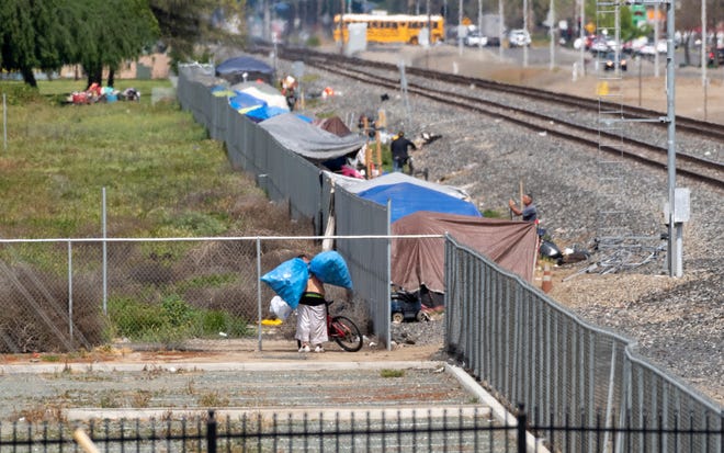 Dozens of homeless have set up shelters along the railroad tracks west of J Street between Prosperity and Cross avenues on Wednesday, April 3, 2019.