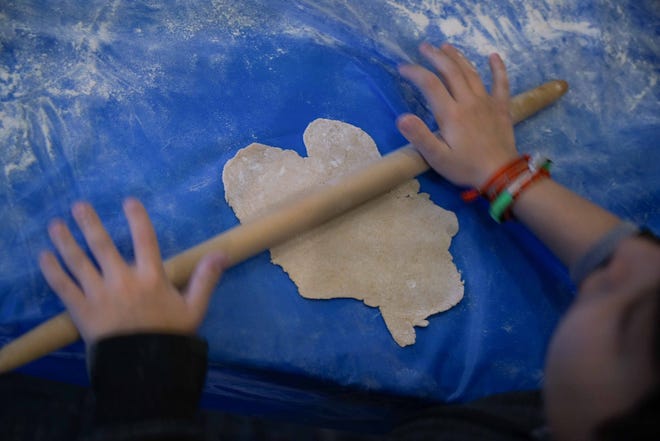 A child from Albert Einstein Academy rolls out fresh matzah for Passover in the Model Matzah Bakery.