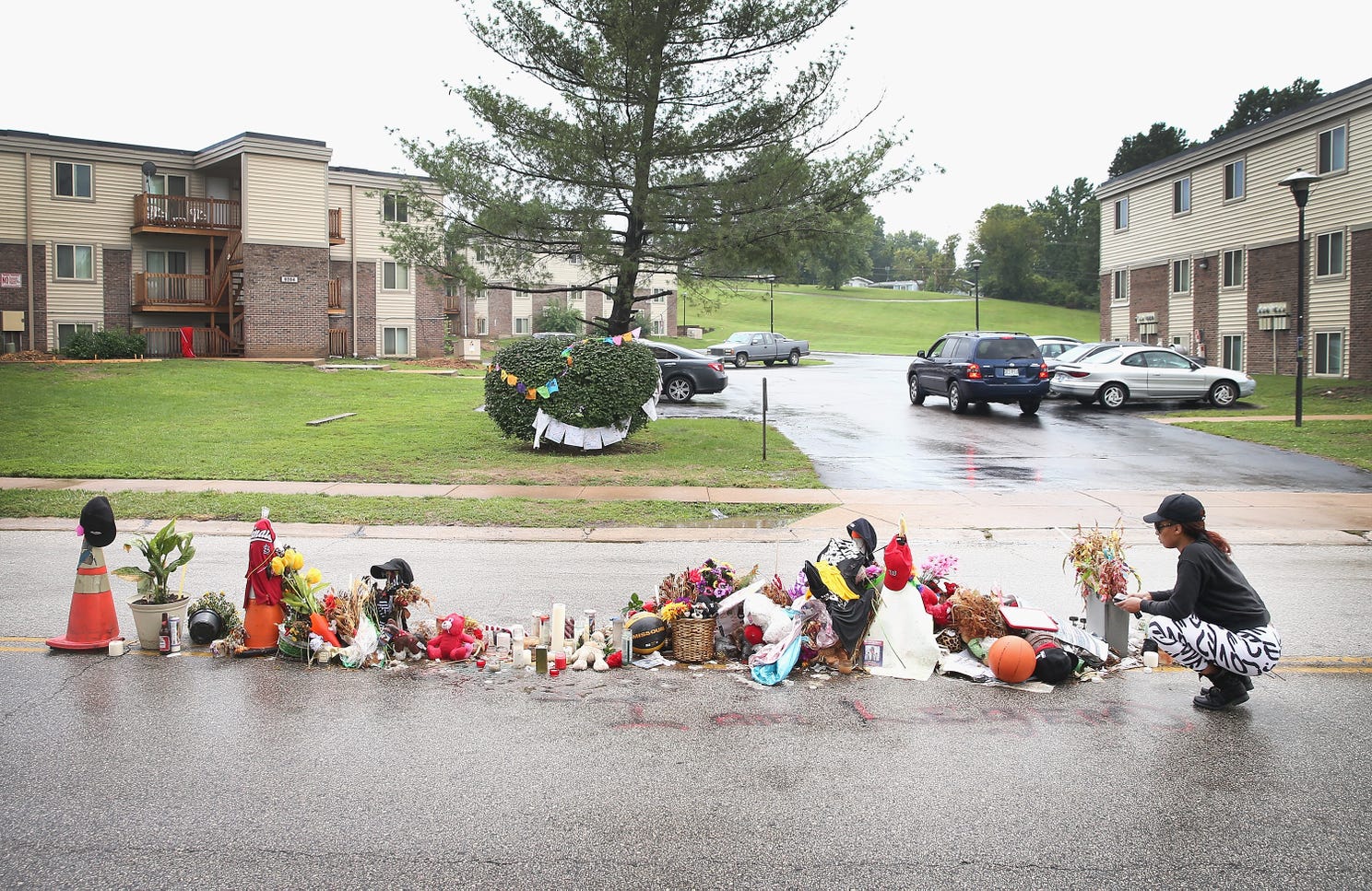 Tamika Staton leaves a message at a memorial in the middle of the road where teenager Michael Brown died after being shot by a police officer in 2014 in Ferguson, Mo., an incident that sparked investigations, protests and a nationwide discussion about policing.