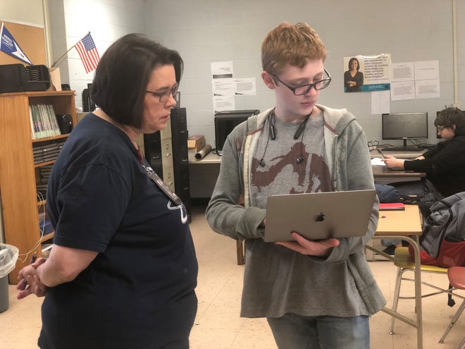 Karen Cavaness, the certified computer science instructor at Crockett County High School, assists student Hunter Park as he creates a dinosaur character during an assignment.