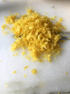Fine shreds of lemon zest can be achieved with a rasp grater or the fine side of a box grater. Be sure to avoid the white pith of the peel.