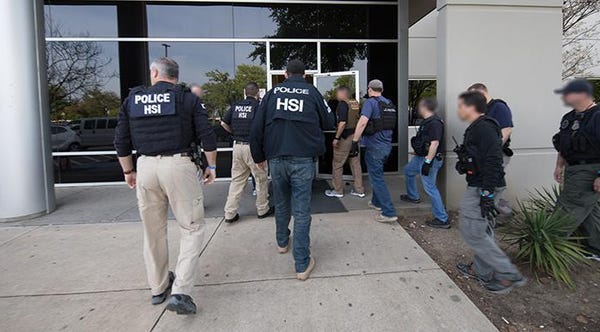 ICE agents enter a business in Allen, Texas, on...