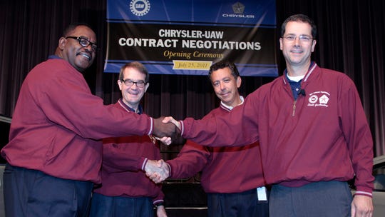 Former UAW Vice President General Holiefield, left, and President Bob King, shake hands with Fiat Chrysler Vice President Alphons Iacobelli and Chrysler Senior Vice President of Manufacturing Scott Garberding in July 2011 to mark the start of contract negotiations.