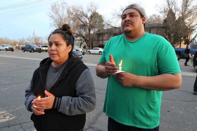 Marissa Etcitty, left, and Billy Freeman, right, hold their candles during a vigil for five-year-old Azarius Lamotte Thursday evening at the Village Apartment complex. Lamotte's father, Fernando Azofeifa, is accused of murdering his son.