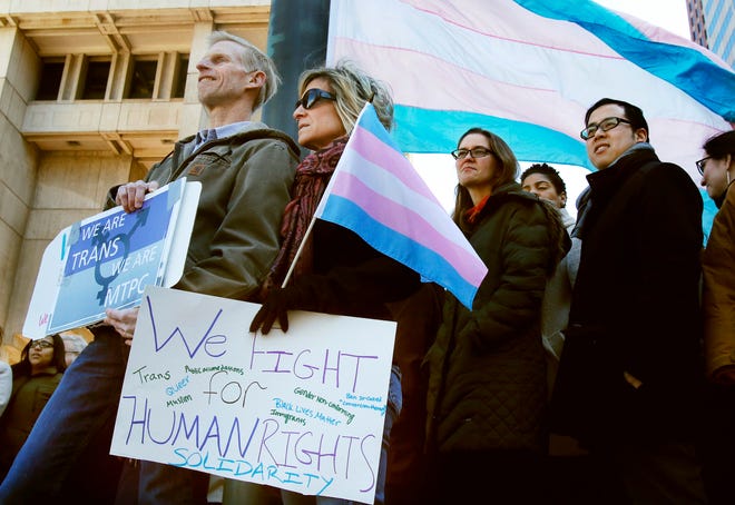 Eric and Evas Nelson, from Sandwich, Mass., and parents of a transgender child, wait for Boston Mayor Marty Walsh to arrive to raise a flag supporting the transgender community at City Hall, on March 30, 2017, in Boston.