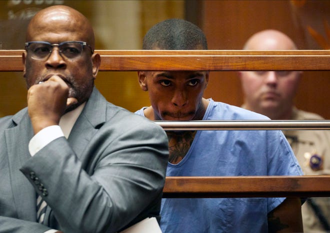 Eric Holder, center, the suspect in the killing of rapper Nipsey Hussle appeared in Los Angeles County Superior Court with his attorney Christopher Darden, left, on Thursday. Holder pleaded not guilty a charge of murder and two counts of attempted murder.