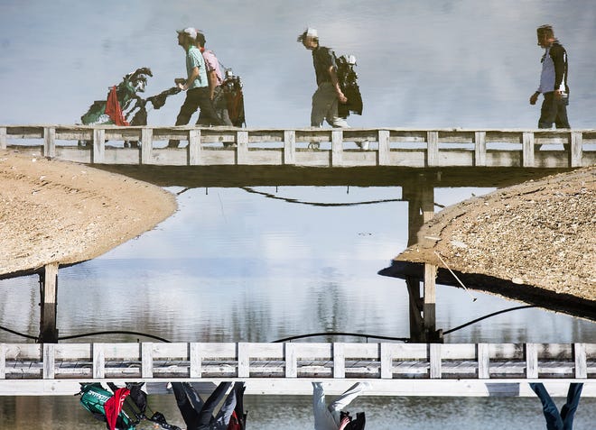FILE -- High school golfers walk across a bridge at The Players Club during an invite on April 6, 2019. The Player's Club is one of seven sites that will host and IGA state qualifier on June 8, 2020.