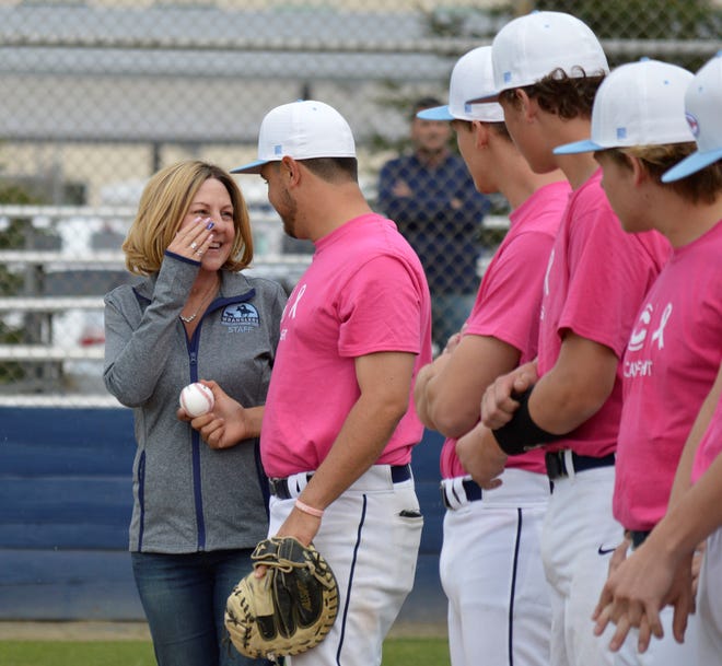 Central Valley Christian High School baseball coach Shane Marshall hands his mother, Stacey, the game ball on Friday in a Central Sequoia League contest. Stacey was diagnosed with breast cancer in December 2018.