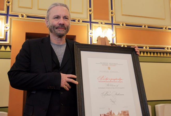 Bruce Dickinson poses for cameras with his honorary citizen certificate at the city hall in Sarajevo, Bosnia-Herzegovina on April 6, 2019.
