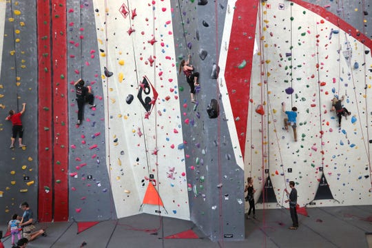 People climb at Adventure Rock, 2220 N. Commerce St. The gym is among those that are participating in an upcoming fitness crawl.