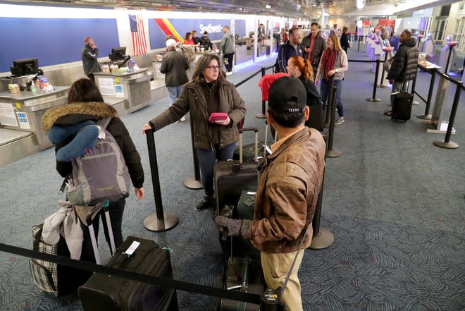 People wait in line to check their bags at the Southwest Airlines ticket area at Mitchell International Airport in Milwaukee.