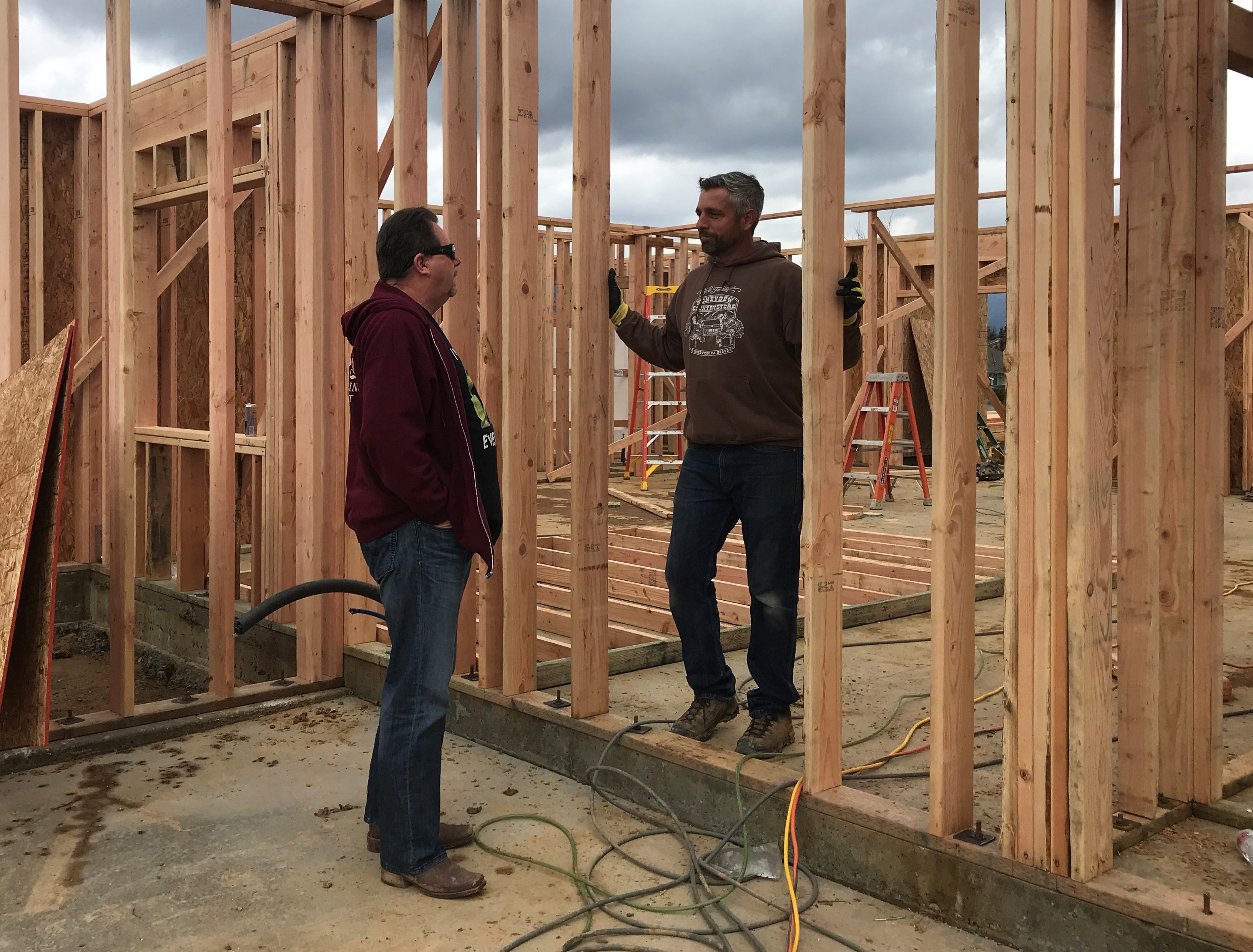 Homeowner Randy Ledbetter Sr., left, talks to contractor Aaron Jones as crews work to rebuild Ledbetter's home in Lake Keswick Estates.