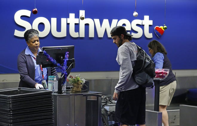 Tonja Longshore, Customer Service Agent at Southwest Airlines helps a customer Tuesday, Dec. 20, 2016 in at Phoenix International Airport  in Phoenix, Ariz.