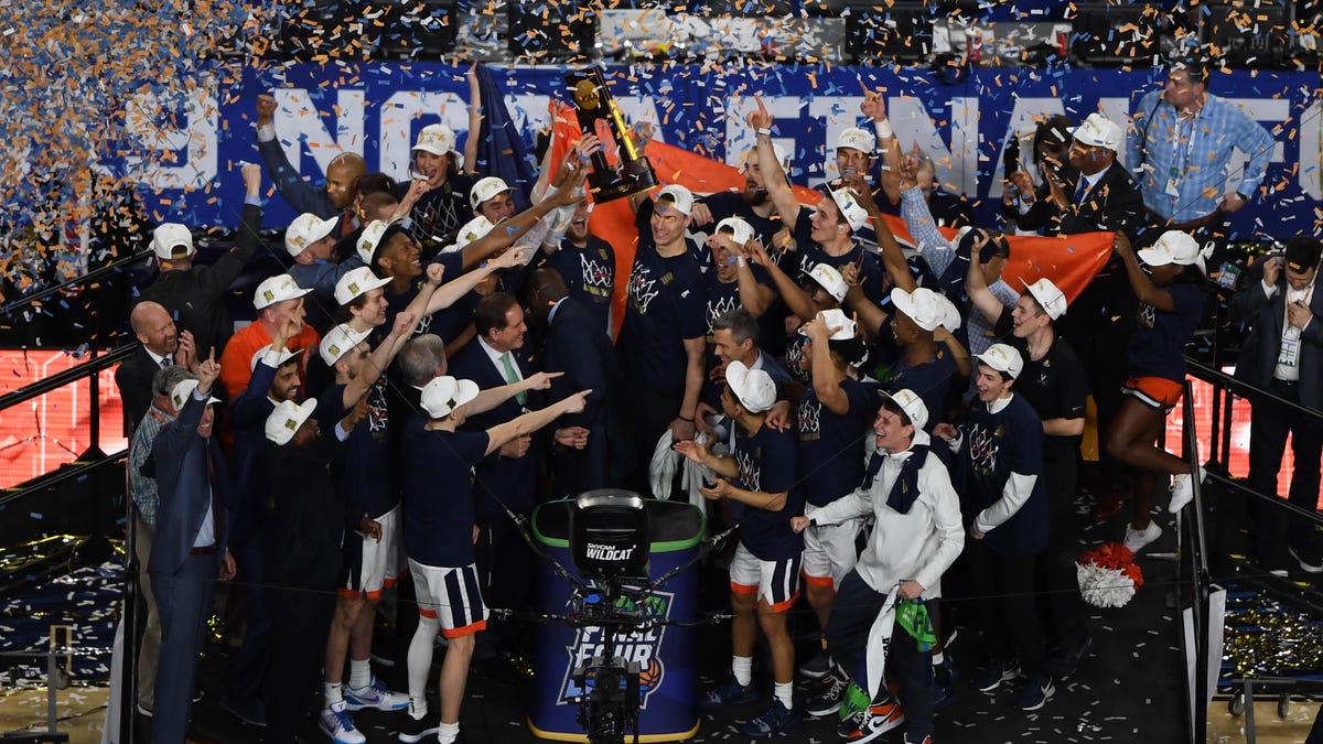 Virginia Cavaliers players celebrate with the trophy after defeating the Texas Tech Red Raiders in the national championship game.