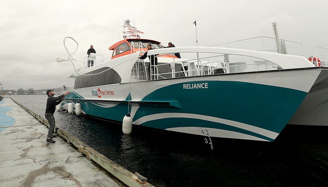 Marine engineer Nick Taylor, (left) gets ready to catch the lines tossed by senior deck hand Lou Trevino (center) as Kitsap Transit's new fast ferry the Reliance docks in Port Orchard on Wednesday, April 10, 2019. 