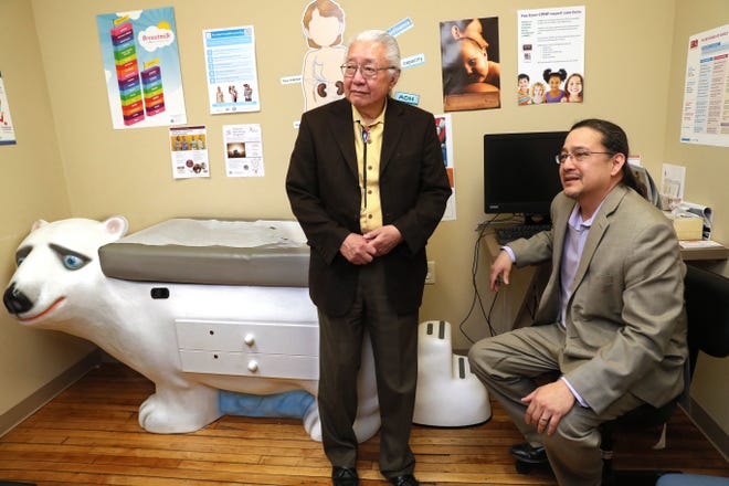 Physician Gerald Ignace with his son, physician Lyle Ignace in a pediatric exam room at the Gerald L. Ignace Indian Health Clinic on Milwaukee's south side. Gerald Ignace was a co-founder of the clinic in 1973.