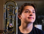 Samuel Osornio, 15, a student at Mesa High School, poses with his trombone at home, Feb. 22, 2019.