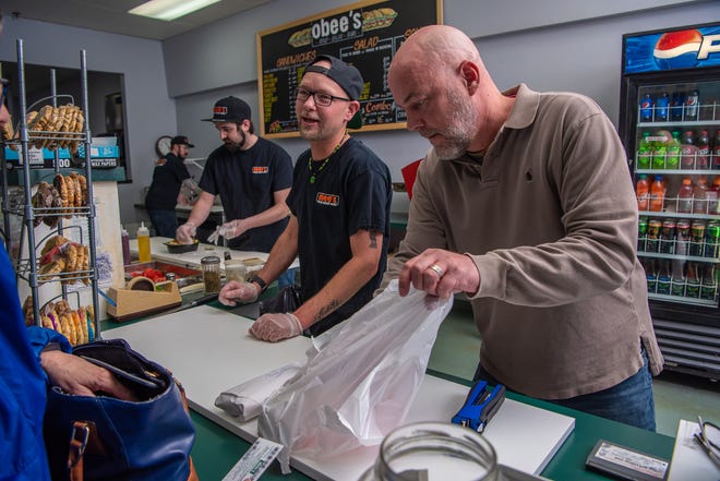 Jeremy Block, co-owner of Obee's, bags a customer's lunch on Wednesday, April 10, 2019, in Fort Collins, Colo.  Block recently purchased the sandwich shop from Lou Jerome, who owned the business for 17 years.