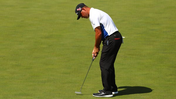 Gary Woodland putts on the 15th green during the...