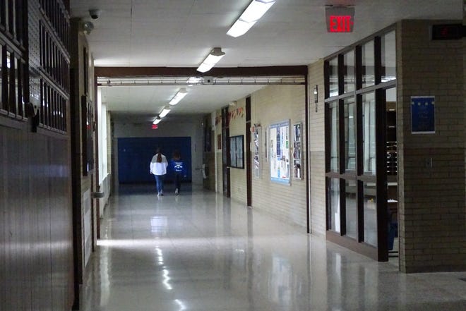 A gate that rolls down from the ceiling in the corridor outside the Wynford High School office marks the division between the portions of the existing building that will be demolished and parts that will be renovated. The near side will be demolished. It was photographed in 2019, before construction of the new building began.