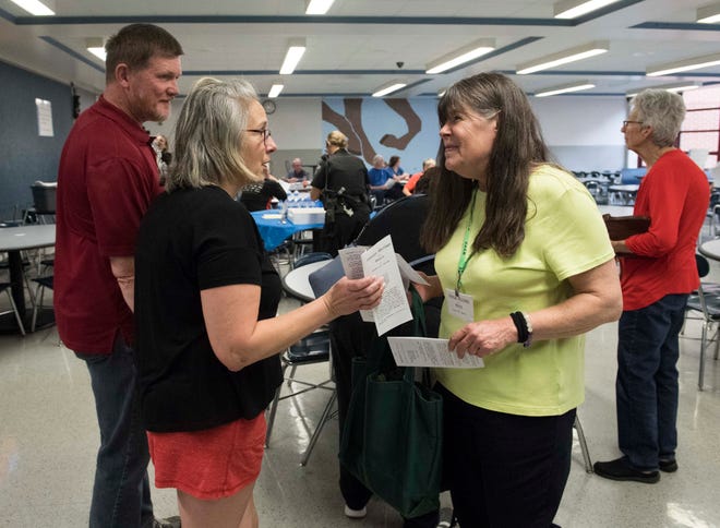 Connie Whitman, right, hands a campaign flyer to Mindy Moats during the Plaza Park Neighborhood Association meeting Thursday, April 11, 2019. Whitman is an Independent, running as a Republican, against Evansville Mayor Lloyd Winnecke.