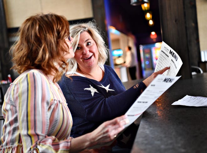 Amy Curran, back, and Liz Orendorf, both of York Township, discuss the menu while dining for lunch at White Rose at Bridgewater, which overlooks the Bridgewater Golf Course in York Township, Friday, April 12, 2019. Curran, who lives nearby, says she was at the restaurant the previous night and planned to dine there again for dinner on Friday. Dawn J. Sagert photo