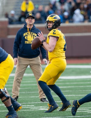 Michigan QB Shea Patterson looks for an open receiver with head coach Jim Harbaugh looking on during the scrimmage.