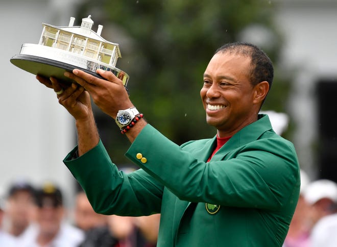 Apr 14, 2019; Augusta, GA, USA; Tiger Woods celebrates with the green jacket and trophy after winning The Masters golf tournament at Augusta National Golf Club. Mandatory Credit: Michael Madrid-USA TODAY Sports