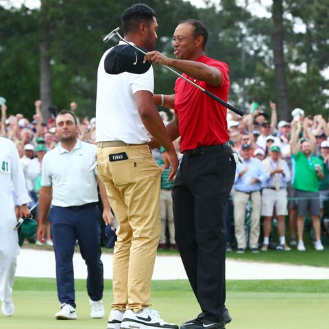 Tiger Woods (right) greets Tony Finau after...